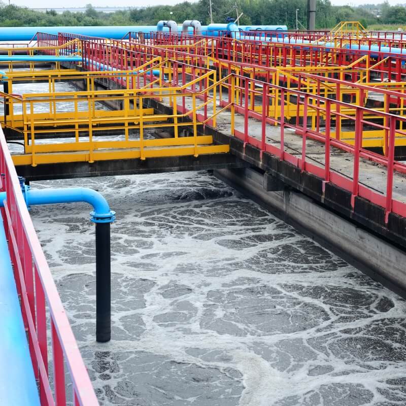 A wide shot showcasing numerous FRP fittings seamlessly integrated into the complex pipe network of a modern water treatment plant